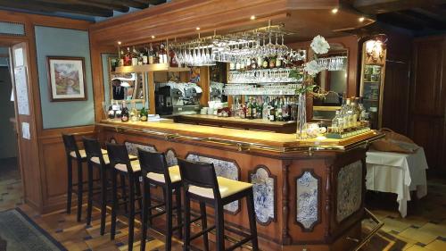 Um bar com um monte de cadeiras à volta. em LOGIS - Hôtel & Restaurant Le Gonfalon em Germigny-lʼEvêque