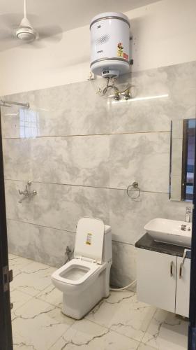 a bathroom with a toilet and a sink at Basera by the Woods in Dehradun