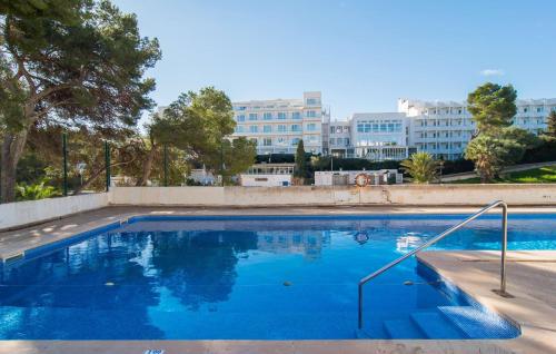 a large blue swimming pool with buildings in the background at Playa D'or in Cala d´Or