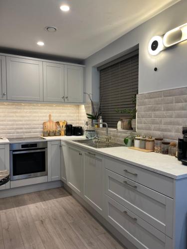 a kitchen with white cabinets and a stove top oven at Haven Stays - D15A5DF in Tyrrelstown