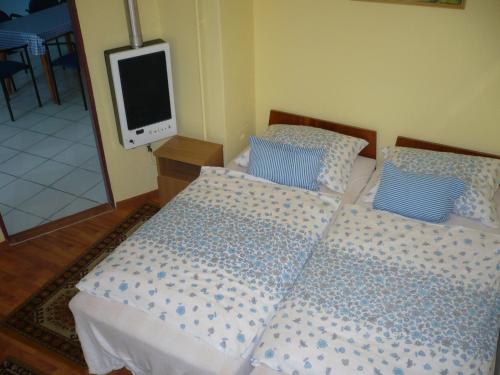 フォニョードにあるCsocsó Nyaralóházのベッドルーム1室(ベッド2台、壁掛けテレビ付)