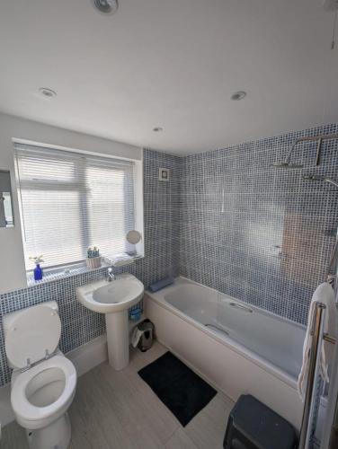 a bathroom with a toilet and a tub and a sink at Romeo's Retreat in Stratford-upon-Avon