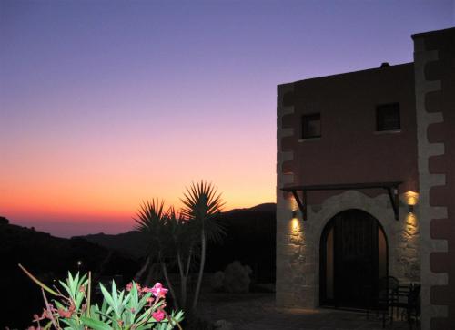 a building with the sunset in the background at Archon Villa in Pandeleḯmon