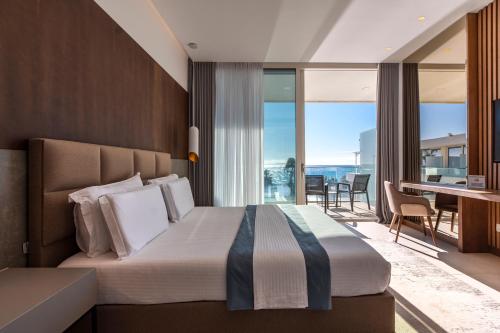 a hotel room with a bed and a balcony at Empire Beach Resort ADULTS ONLY in Dhërmi