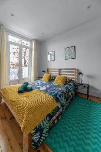 a bedroom with a bed and a large window at Résidence Celestins - Appartements centre avec parking in Vichy