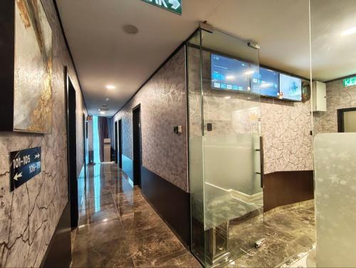 a hallway with a glass shower in a building at Hotel Mawar Inn in Jenjarum