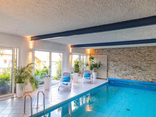 a swimming pool with two blue chairs next to it at B&B Chalet Andy in Schenna