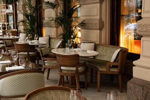 een eetzaal met tafels en stoelen in een restaurant bij Hotel Kämp in Helsinki