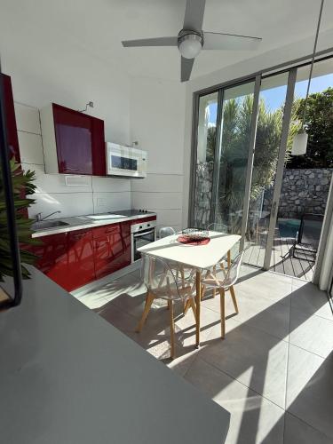 a kitchen with a white table and a kitchen with red cabinets at Stylish villa with private pool in Koolbaai in Koolbaai