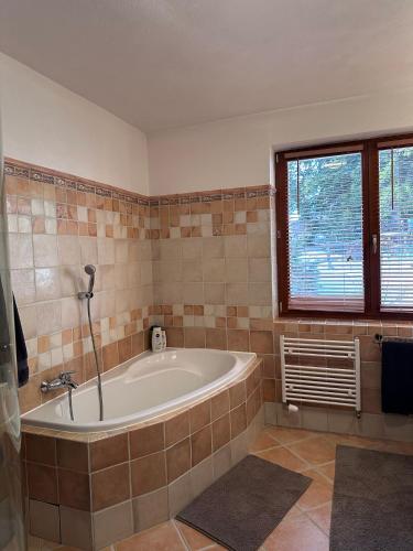 a bathroom with a tub and a window at Apartmán Donovaly 90 in Donovaly