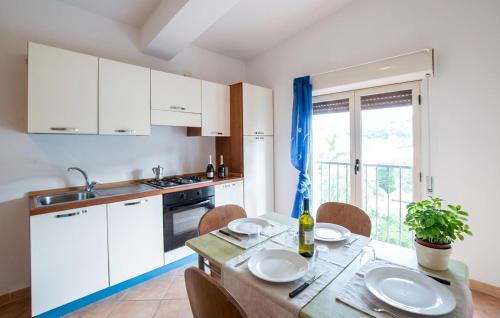 a kitchen with white cabinets and a table with chairs at Awesome Apartment In Palmi in Palmi