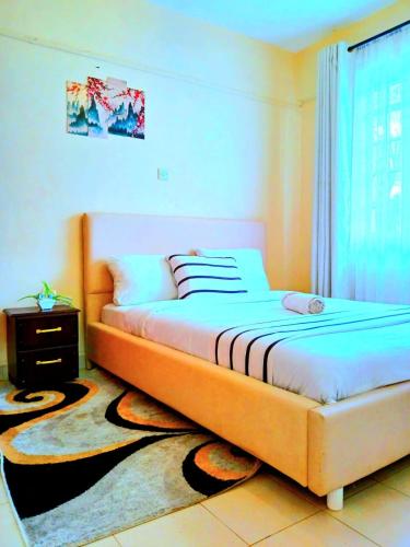 a bedroom with a bed and a window at Ladine Homestay - Ferrum Apartment in Eldoret