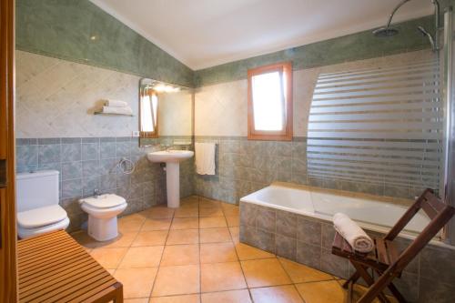 een badkamer met een bad, een toilet en een wastafel bij Can Marines in S'Horta
