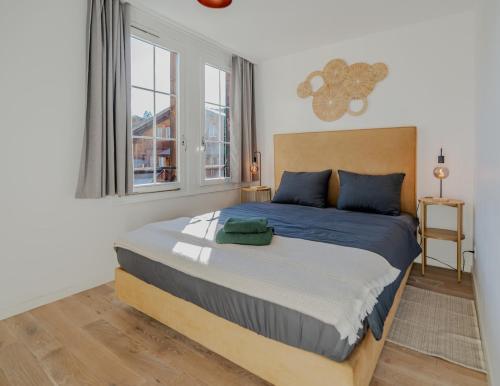 a bedroom with a large bed with blue pillows at Central City Apartment 1 with Mountain View in Zweisimmen