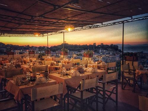 a restaurant with tables and chairs with the sunset in the background at Hotel La Villarosa Terme in Ischia