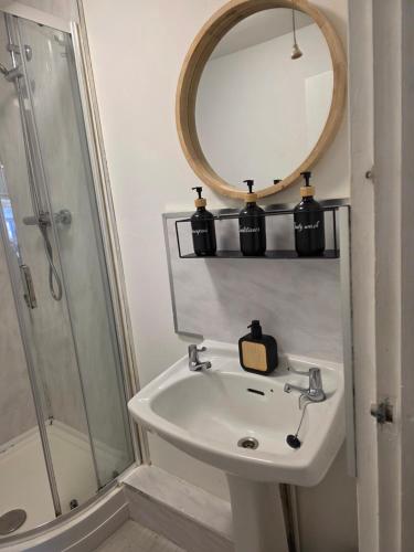 a bathroom with a sink and a mirror at Horizon Hideaway in Swansea