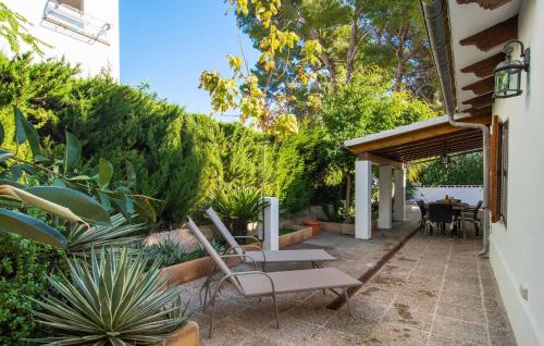 a patio with chairs and a table and some plants at Es Baladre Beach in Alcudia