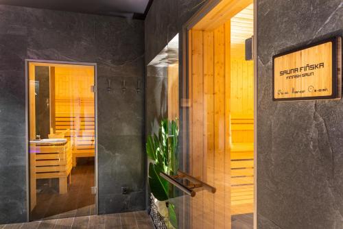 a bathroom with a walk in shower and a mirror at Hotel Bażantowo Sport in Katowice