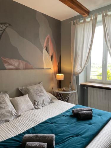 a bedroom with a large bed with a blue blanket at Chambres d'hôtes du Domaine de la Manse in Villeneuve-de-Berg