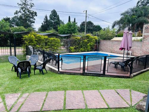 a fence with chairs and a pool in a yard at Canoas Apart in Colón