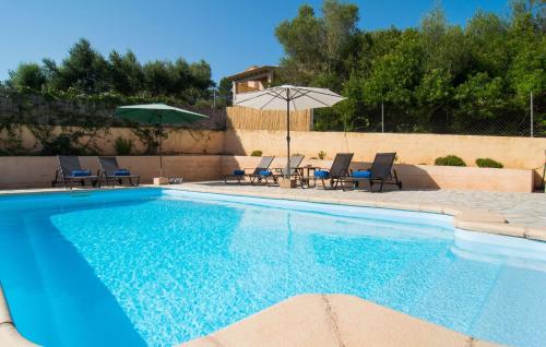 a swimming pool with chairs and an umbrella at Sa Finqueta in Manacor