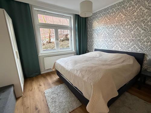 a bedroom with a bed and a window at Kalkberg Ferienwohnungen in Bad Segeberg