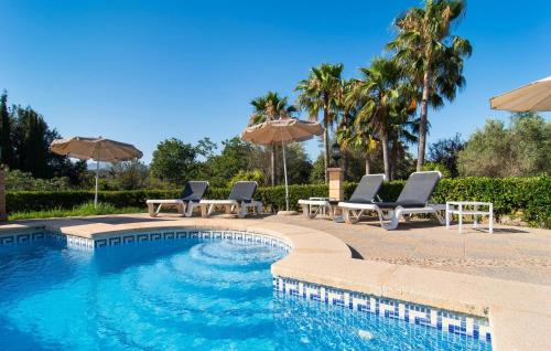 a swimming pool with lounge chairs and umbrellas at Na Peixet in Artá