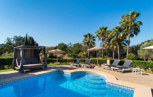 a swimming pool with lounge chairs and umbrellas at Na Peixet in Artá