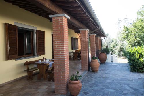 a brick patio with tables and potted plants at Agriturismo Poggetto in Larciano