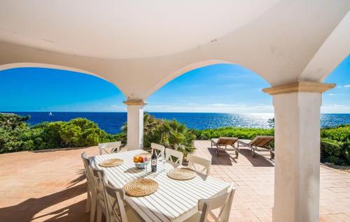 a patio with a table and chairs and the ocean at Can Roca De Cala D'or in Cala d´Or