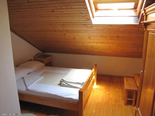 a small room with a bed in a attic at Penzion Sinji vrh in Zoll
