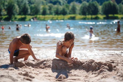 two children playing in the sand at the beach at Camping Base de Loisirs du Lac de la Moselotte in Saulxures-sur-Moselotte