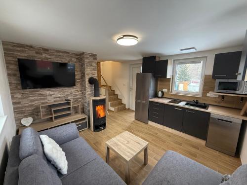 a living room with a couch and a kitchen at Chalet U Pstruha in Vimperk