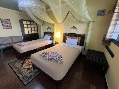 a bedroom with two beds and a couch at Rusty Rock Beach Resort & Spa in Mwanza