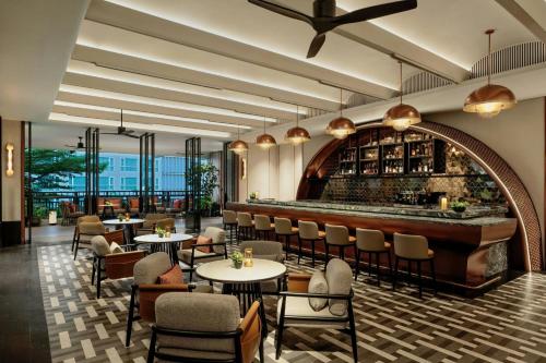 a restaurant with tables and chairs and a bar at Chiang Mai Marriott Hotel in Chiang Mai