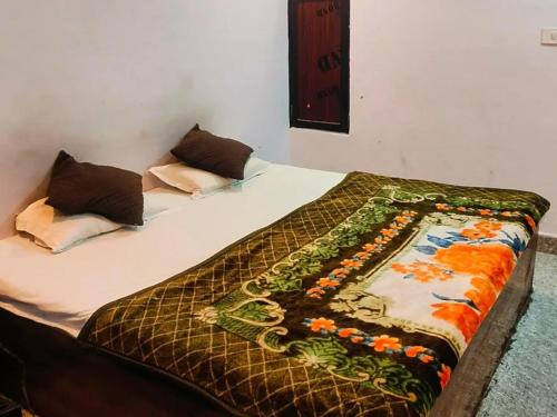 a bed with a comforter and pillows on it at Hotel Ayodhya Palace in Farrukhābād