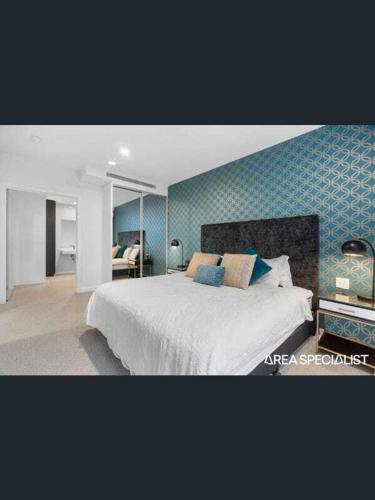 a bedroom with a large bed with a blue wall at apartment in Tryp by Wyndham near broadwater in Gold Coast
