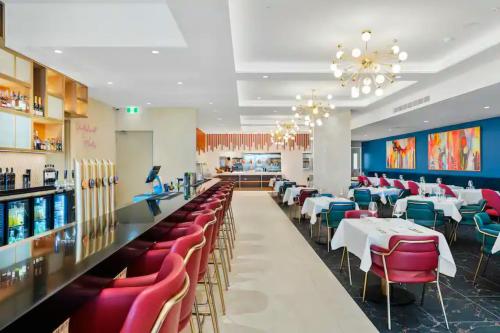 a restaurant with tables and chairs and a bar at apartment in Tryp by Wyndham near broadwater in Gold Coast