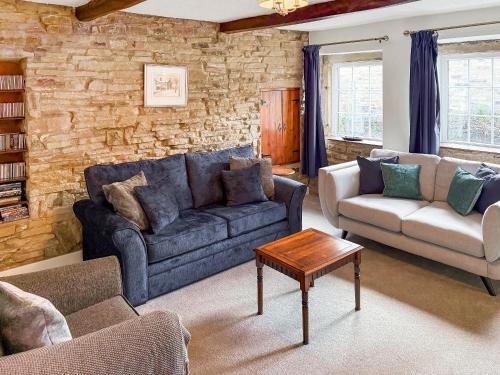 a living room with a couch and a table at Wellhead Cottage in Haworth