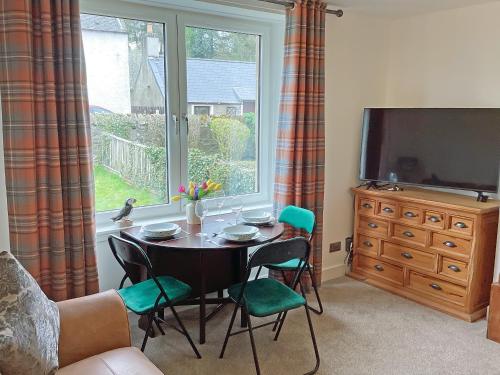 a living room with a table and chairs and a window at Seasgair in Dingwall