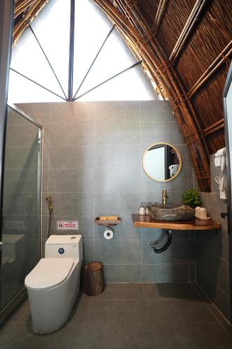 a bathroom with a toilet and a sink and a mirror at Cat Ba Holiday Retreat in Cat Ba