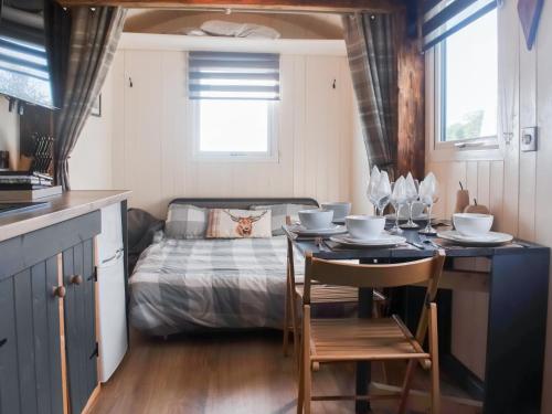 a kitchen with a table and a bed in a room at Shepherds Hut - Uk50043 in Chipping
