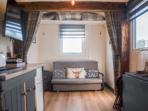 a living room with a couch in a tiny house at Shepherds Hut - Uk50043 in Chipping