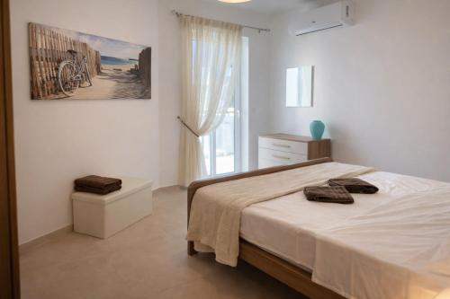 a bedroom with a bed with two towels on it at Comfortable ! Stylish ! Fully Air Conditioned ! in Sannat