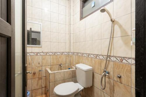 a bathroom with a toilet and a shower at RedDoorz Syariah near Pasar Pagi Samarinda in Samarinda
