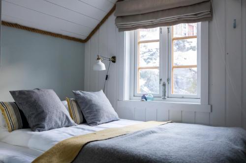 a bedroom with a bed and a window at Kuringen Brygge Hotel and Restaurant in Refsnes