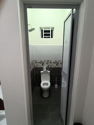a small bathroom with a toilet and a window at Airisafiq Homestay in Kampong Sungai Rambai