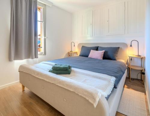 a bedroom with a large bed with blue and pink pillows at Central City Apartment 2 with Mountain View in Zweisimmen