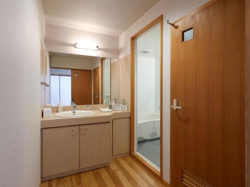 a bathroom with a sink and a mirror at Ikoi no mura Notohanto in Shika