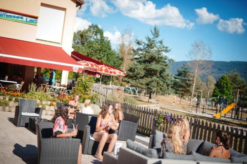 a group of women sitting in chairs outside a restaurant at Camping Base de Loisirs du Lac de la Moselotte in Saulxures-sur-Moselotte